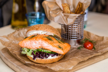 Restourant serving dish - burger with salmon, frying potato on w