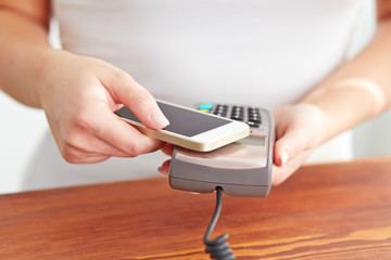 Woman paying with NFC technology on mobile phone