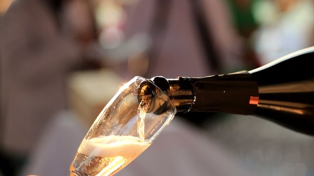 wine steward pouring prosecco or champagne in a glass