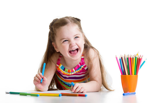 Cheerful child girl drawing with pencils in preschool
