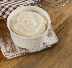 Mayonnaise in  a bowl   on  wooden background