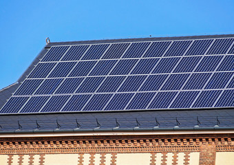 Naklejka premium Solar panels on the roof of an old building
