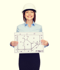 smiling businesswoman in helmet showing blueprint