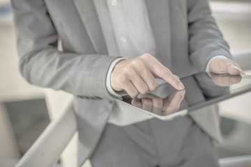 Businessman using electronic tablet pc. He is sitting on a stair