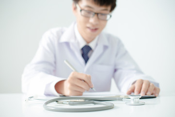 Fototapeta premium Close-up Of Male Doctor Filling The Medical Form