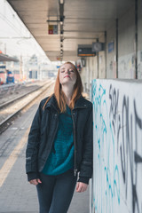 Beautiful girl posing in a railroad station