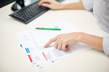 close up of woman hands with papers and computer