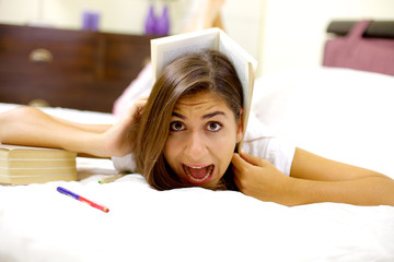 Girl tired of studying screaming with book on head