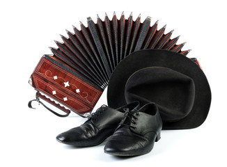 Bandoneon, pair of tango shoes and a black hat