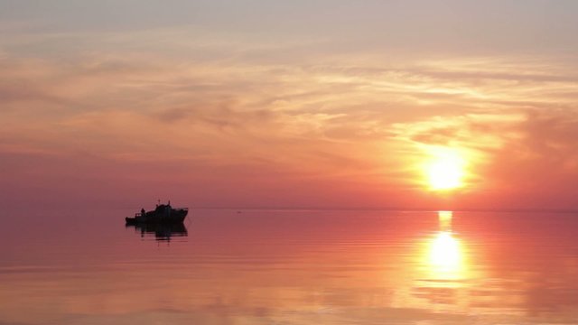 video of a floating boat at sunset