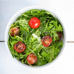 Mixed salad with arugula, cherry tomatoes and sesame seeds.
