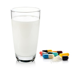 pill and glass of milk isolated on white background