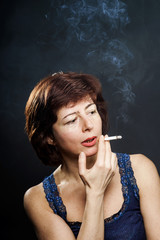 Obraz premium Young woman smoking cigarette, healthcare concept