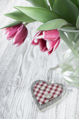 Pink tulips and wooden heart, text space