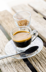 Espresso coffee in glass cup on wooden table