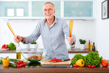 Mature man in the kitchen prepare salad IV