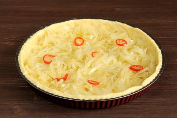 Open onion pie with chili on wooden background