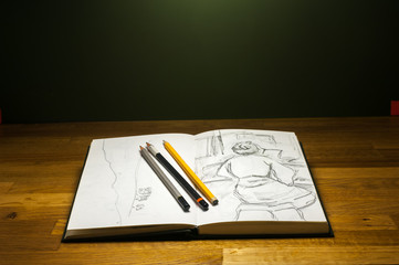 sketchbook with beginner pencil drawings on school table