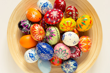 colorful easter eggs in wooden bowl