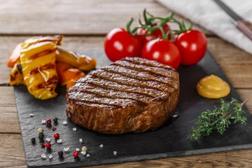 Vitrage gordijnen Steakhouse grilled beef steak with vegetables on a wooden surface