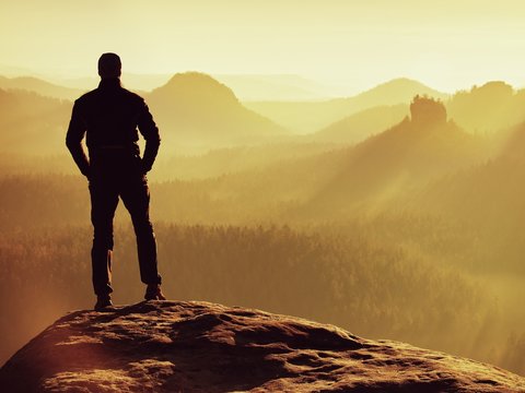 Hiker is standing on the peak of sandstone rock in rock empires 