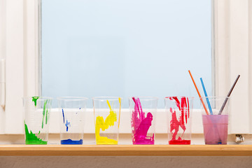 Stillleben von mehreren Farbbechern auf der Fensterbank