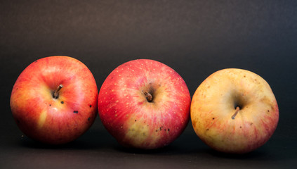 Three apples on black background
