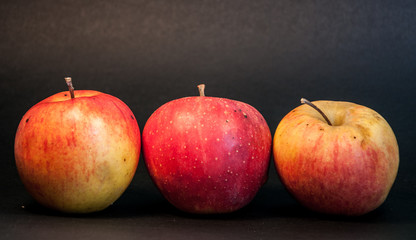 Three apples on black background
