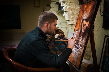 Young painter working on oil painting portrait