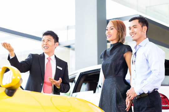 Asian Couple Buying Car In Dealership