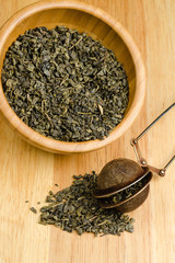 green tea, dried leaves with filter, on wooden background