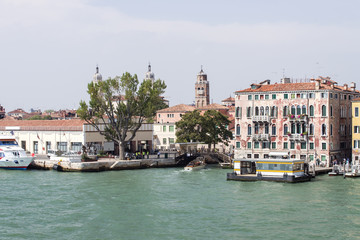 Fototapeta na wymiar Quay and water bus stop at channel in Venice