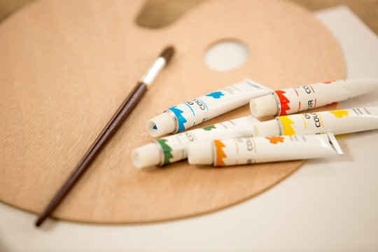 Macro shot of oil paint tubes an paintbrush lying on pallet