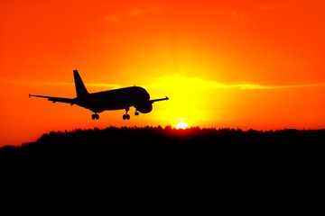 Silhouette of the plane landing above the sunrise