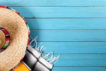 Poster Mexican background with sombrero straw hat and traditional serape rug or blanket on old blue planked wood Mexico holiday vacation cinco de mayo photo © david_franklin