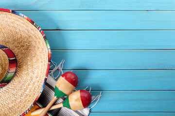 Mexican background with sombrero straw hat and traditional serape rug or blanket on old blue...