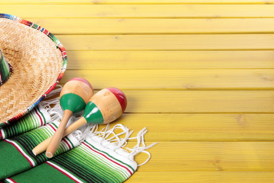 Mexican background with sombrero straw hat maracas and traditional serape rug or blanket on old planked pine wood Mexico holiday vacation cinco de mayo photo horizontal