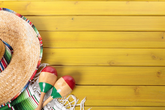 Mexican background with sombrero straw hat maracas and traditional serape rug or blanket on old planked pine wood Mexico holiday vacation cinco de mayo photo 
