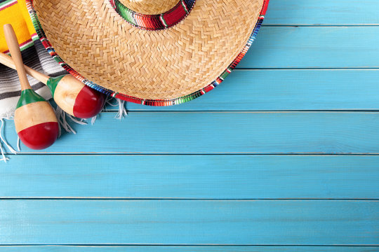 Mexican background with sombrero straw hat maracas and traditional serape rug or blanket on old planked blue wood Mexico holiday vacation cinco de mayo photo 