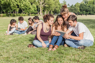 Fototapeta premium Friends using tablet in the park
