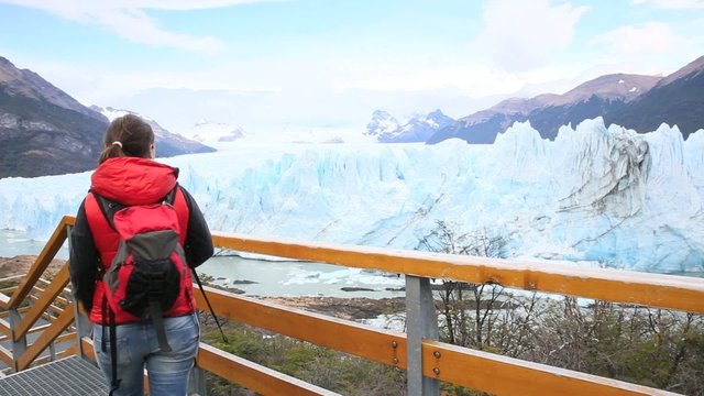 Tourist walking on Perito Moreno footbridge by Argentino lake