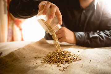 male miner emptying jar with golden nuggets