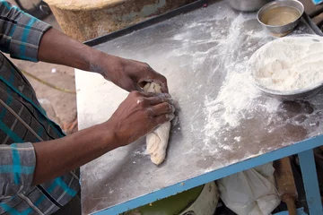 Selbstklebende Fototapeten Closeup of man's hands making chapati at streetside restaurant i © donyanedomam
