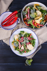 Frozen vegetables on plate on napkin, on wooden table