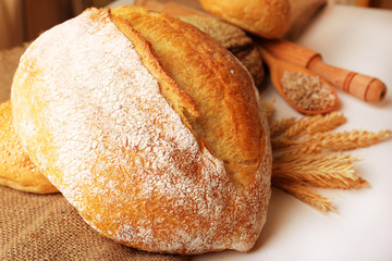 Fresh bread with wheat and wooden spoon of sunflower seeds,