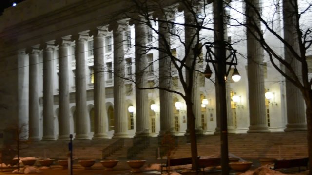 Panning across the columns of a US Courthouse at night