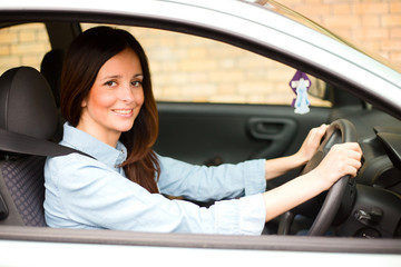 young woman drinving her car wearing her seatbelt.