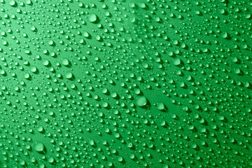 Water drops on glass on green background
