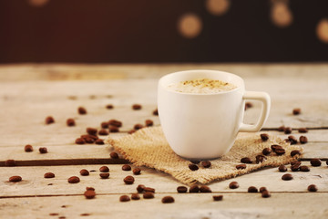 Cup of coffee on table on brown background