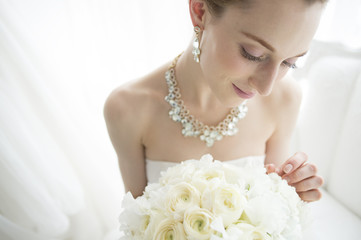 Happy bride looking at the bouquet
